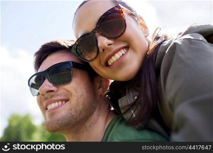 travel, hiking, backpacking, tourism and people concept - happy couple in sunglasses having fun outdoors