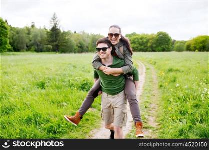 travel, hiking, backpacking, tourism and people concept - happy couple with backpacks having fun and walking along country road outdoors
