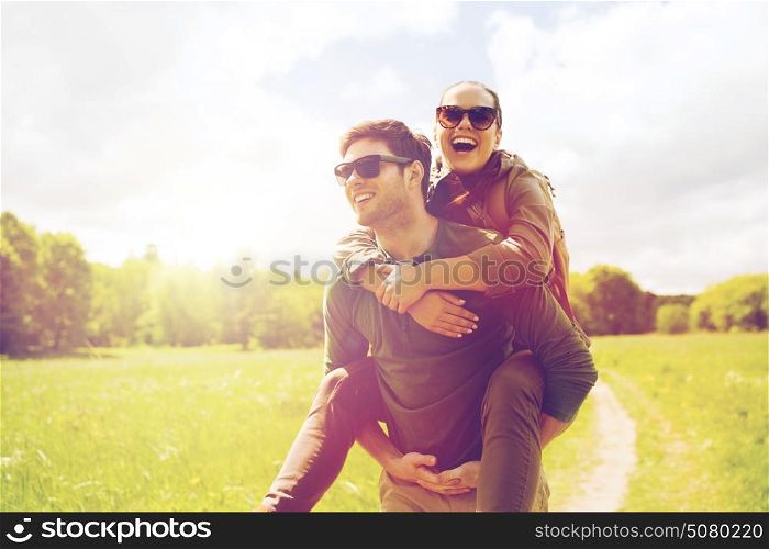 travel, hiking, backpacking, tourism and people concept - happy couple with backpacks having fun and walking along country road outdoors. happy couple with backpacks having fun outdoors
