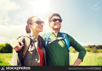 travel, hiking, backpacking, tourism and people concept - happy couple with backpacks hugging and walking outdoors. happy couple with backpacks hiking outdoors. happy couple with backpacks hiking outdoors