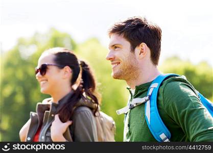 travel, hiking, backpacking, tourism and people concept - happy couple with backpacks walking outdoors