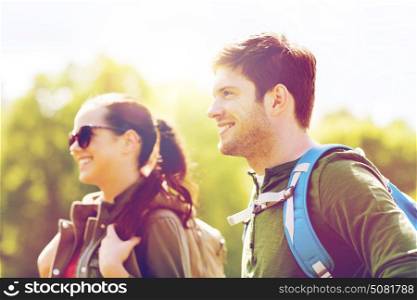 travel, hiking, backpacking, tourism and people concept - happy couple with backpacks walking outdoors. happy couple with backpacks hiking outdoors