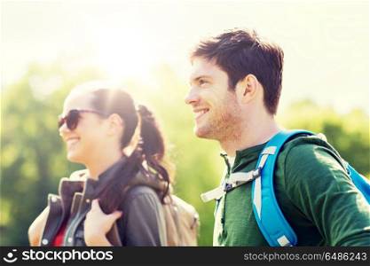 travel, hiking, backpacking, tourism and people concept - happy couple with backpacks walking outdoors. happy couple with backpacks hiking outdoors. happy couple with backpacks hiking outdoors