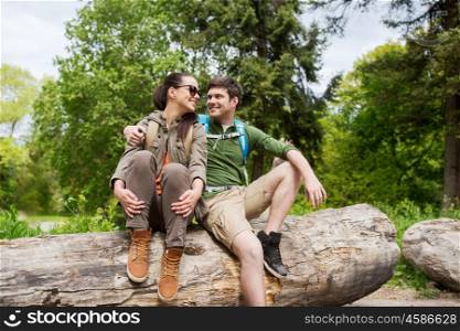 travel, hiking, backpacking, tourism and people concept - smiling couple with backpacks resting and hugging in nature