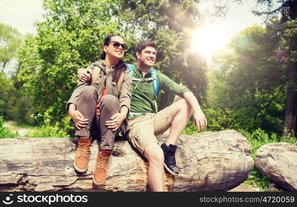 travel, hiking, backpacking, tourism and people concept - smiling couple with backpacks resting and hugging in nature. smiling couple with backpacks in nature. smiling couple with backpacks in nature