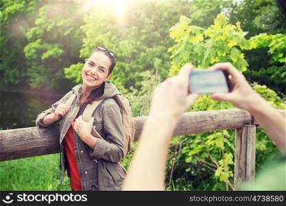 travel, hiking, backpacking, tourism and people concept - smiling couple with backpacks taking picture by smartphone in nature. couple with backpacks taking picture by smartphone. couple with backpacks taking picture by smartphone