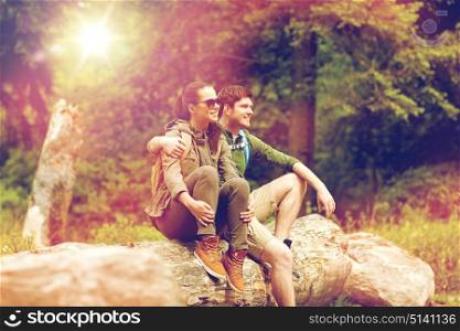 travel, hiking, backpacking, tourism and people concept - smiling couple with backpacks resting and hugging in nature. smiling couple with backpacks in nature