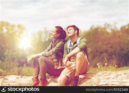 travel, hiking, backpacking, tourism and people concept - smiling couple with backpacks resting and enjoying sun in nature. smiling couple with backpacks in nature