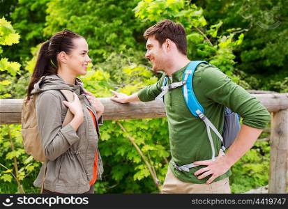 travel, hiking, backpacking, tourism and people concept - smiling couple with backpacks in nature