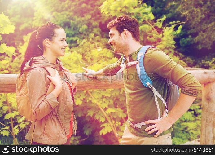 travel, hiking, backpacking, tourism and people concept - smiling couple with backpacks in nature. smiling couple with backpacks in nature