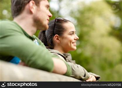 travel, hiking, backpacking, tourism and people concept - smiling couple with backpacks on bridge in nature