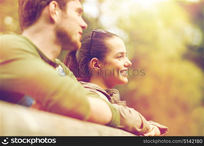 travel, hiking, backpacking, tourism and people concept - smiling couple with backpacks on bridge in nature. smiling couple with backpacks on bridge in nature