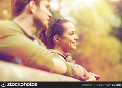 travel, hiking, backpacking, tourism and people concept - smiling couple with backpacks on bridge in nature. smiling couple with backpacks on bridge in nature