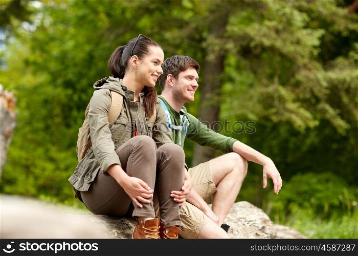 travel, hiking, backpacking, tourism and people concept - smiling couple with backpacks resting in nature