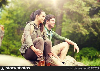 travel, hiking, backpacking, tourism and people concept - smiling couple with backpacks resting in nature. smiling couple with backpacks in nature. smiling couple with backpacks in nature