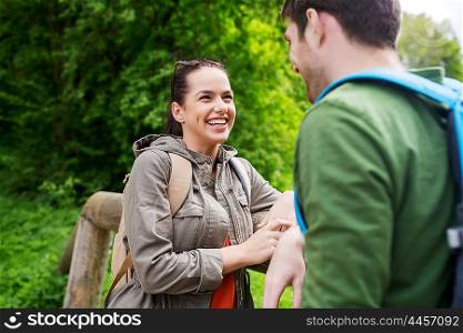 travel, hiking, backpacking, tourism and people concept - smiling couple with backpacks talking in nature
