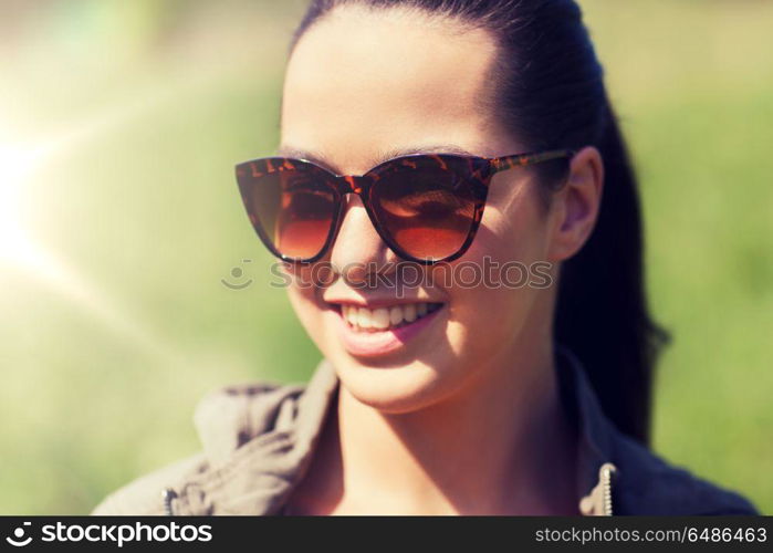 travel, hiking, tourism, eyewear and people concept - face of happy young woman in sunglasses outdoors. face of happy young woman in sunglasses outdoors. face of happy young woman in sunglasses outdoors