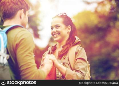 travel, hiking, tourism, love and people concept - happy couple with backpacks holding hands outdoors. happy couple with backpacks hiking outdoors