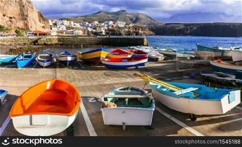 travel in Grand Canary island - traditional fishing village Puerto de Sardina with old colorful boats. Colorful fishing village In Gran Canaria