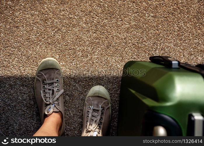 Travel in Summer Concept. Top View of Young Traveler on Sneaker Shoes with Luggage. Standing on Grunge Dirty Concrete Floor with Sunlight