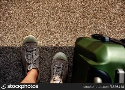 Travel in Summer Concept. Top View of Young Traveler on Sneaker Shoes with Luggage. Standing on Grunge Dirty Concrete Floor with Sunlight