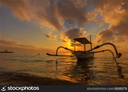Travel in the morning sunrise in Bali, Indonesia. Traditional fishing boats at Sanur beach, Bali, Indonesia.