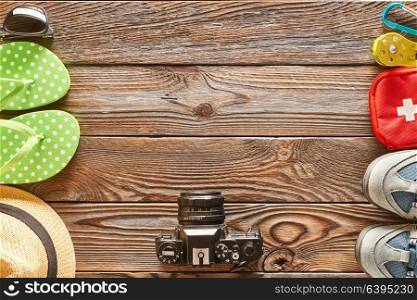 Travel items: beach vs. hike. Still life over wooden background.