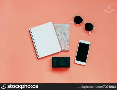 Travel items concept : blank notebook, map, camera, smartphone and sunglasses on yellow background, top view with minimal style