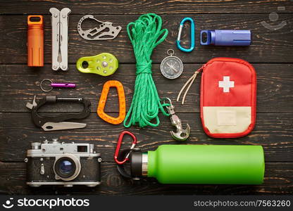 Travel items for hiking tourism still life over wooden background