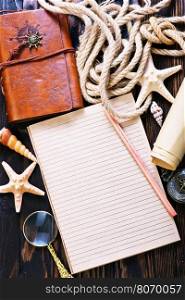 Travel items on wooden table, notebook and shells