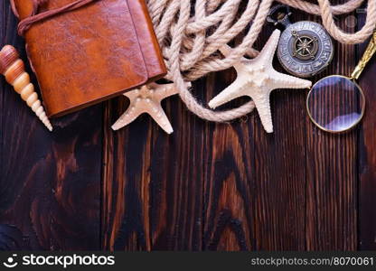 Travel items on wooden table, notebook and shells