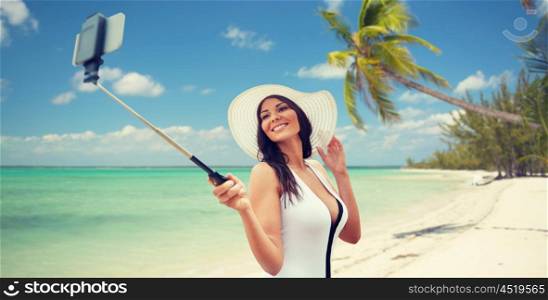 travel, leisure, summer, technology and people concept - sexy young woman taking selfie with smartphone on tropical beach background