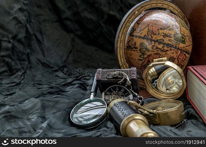 Travel or adventure concept background. Pocket watch, binoculars, antique compass, globe and magnifying glass on dark background. Journey Concept, Copy Space, Vintage Style.