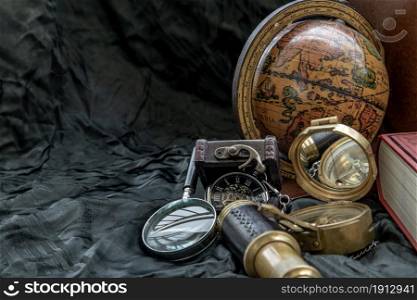 Travel or adventure concept background. Pocket watch, binoculars, antique compass, globe and magnifying glass on dark background. Journey Concept, Copy Space, Vintage Style.