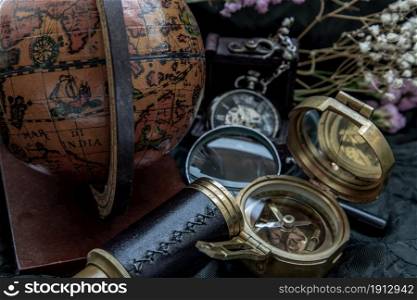 Travel or adventure concept background. Pocket watch, binoculars, antique compass, globe and magnifying glass on dark background. Journey Concept, Vintage Style.