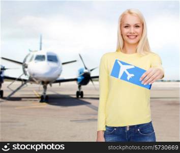 travel, people and transportation concept - smiling young woman with airplane ticket at airport