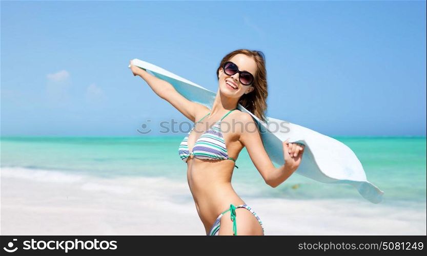 travel, people, summer holidays and vacation concept - beautiful woman in bikini and sunglasses with pareo over exotic tropical beach background. woman in bikini and sunglasses with pareo on beach