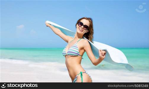 travel, people, summer holidays and vacation concept - beautiful woman in bikini and sunglasses with pareo over exotic tropical beach background. woman in bikini and sunglasses with pareo on beach