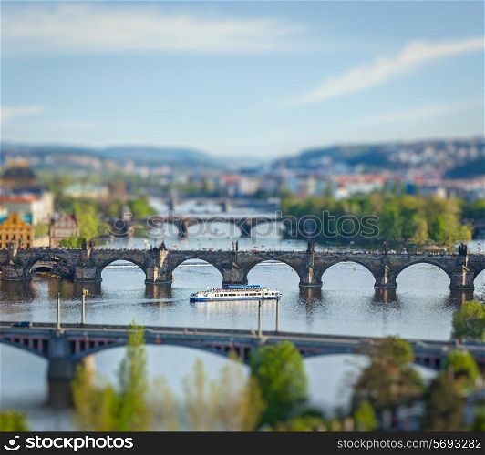 Travel Prague concept background - elevated view of bridges over Vltava river from Letna Park with tilt shift toy effect shallow depth of field. Prague, Czech Republic