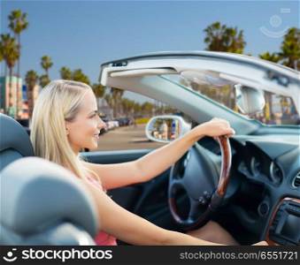 travel, road trip and people concept - happy young woman driving convertible car over venice beach background in california. woman driving convertible car over venice beach. woman driving convertible car over venice beach