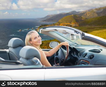 travel, road trip and people concept - happy young woman driving convertible car over bixby creek bridge on big sur coast of california background. woman driving convertible car on big sur coast