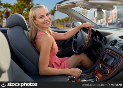 travel, road trip and people concept - happy young woman driving convertible car over venice beach background in california. woman driving convertible car over venice beach