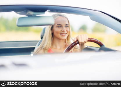 travel, road trip and people concept - happy young woman driving convertible car. happy young woman driving convertible car