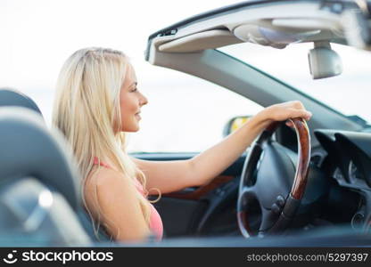 travel, road trip and people concept - happy young woman driving convertible car. happy young woman driving convertible car