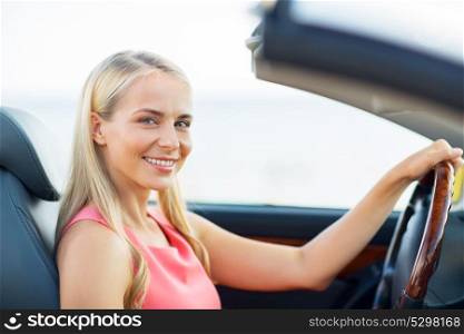travel, road trip and people concept - happy young woman driving convertible car. happy young woman driving convertible car