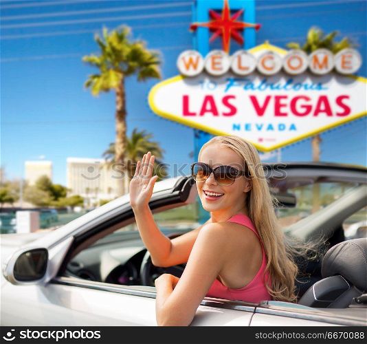 travel, road trip and people concept - happy young woman in convertible car waving hand over welcome to fabulous las vegas sign background. happy young woman in convertible car waving hand. happy young woman in convertible car waving hand