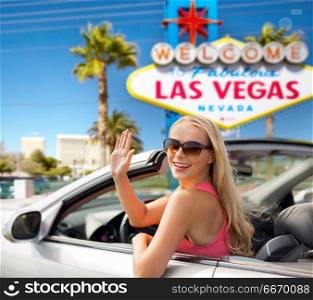 travel, road trip and people concept - happy young woman in convertible car waving hand over welcome to fabulous las vegas sign background. happy young woman in convertible car waving hand. happy young woman in convertible car waving hand