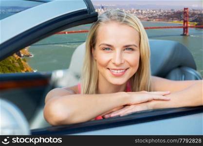 travel, road trip and people concept - happy young woman in convertible car over golden gate bridge in san francisco bay background. woman in convertible car over golden gate