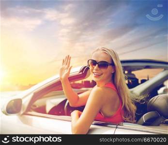 travel, road trip and people concept - happy young woman in convertible car waving hand. happy young woman in convertible car waving hand. happy young woman in convertible car waving hand