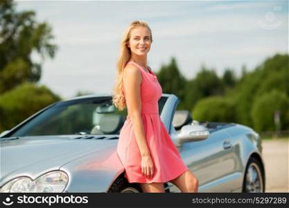 travel, road trip and people concept - happy young woman posing at convertible car. happy young woman posing at convertible car